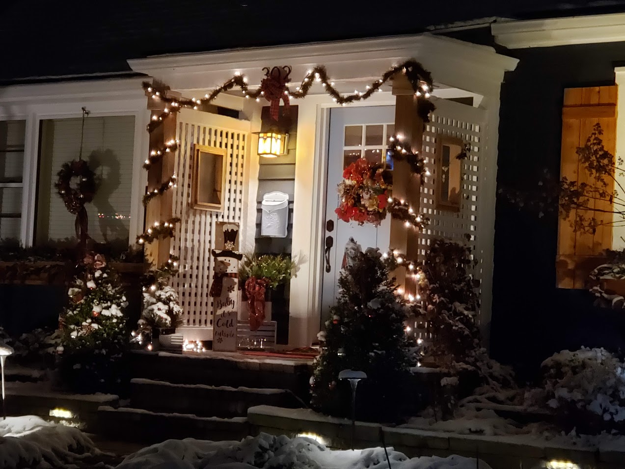 Christmas porch at night with lights and snow